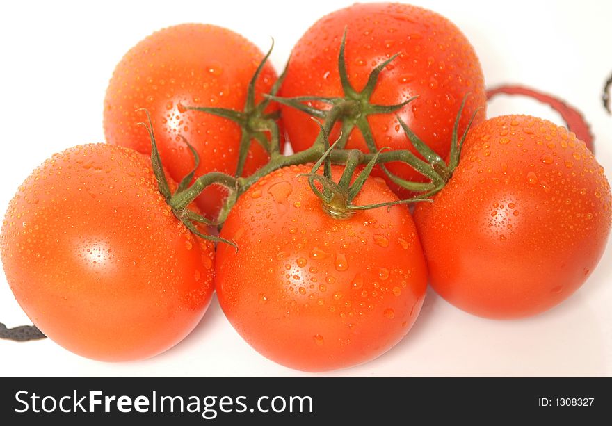 Fresh tomatoes with rain drops in a white dish