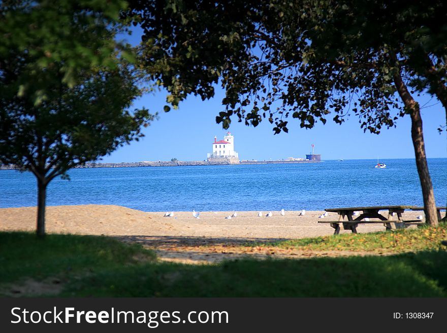 Scene with picnic area and beach in foreground and Fairport Harbor Lighthouse in the background. Scene with picnic area and beach in foreground and Fairport Harbor Lighthouse in the background