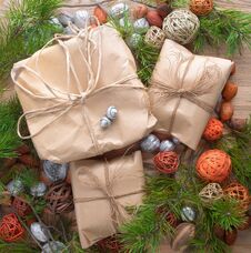 Christmas Gifts In Craft Paper Package Tied A Rope On Wooden Background In A Frame Christmas Tree Branches Decorations. Stock Photography