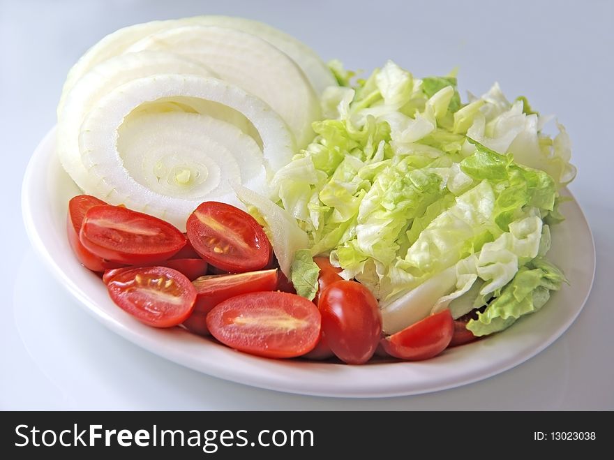 Fresh cut vegetables on a plate in a studio environment