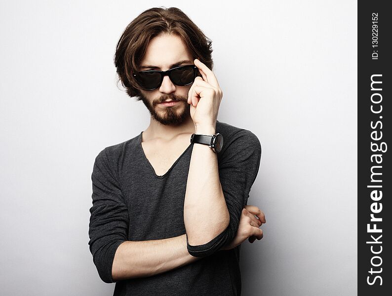 Fashion young man wearing fashionable sunglasses on white background