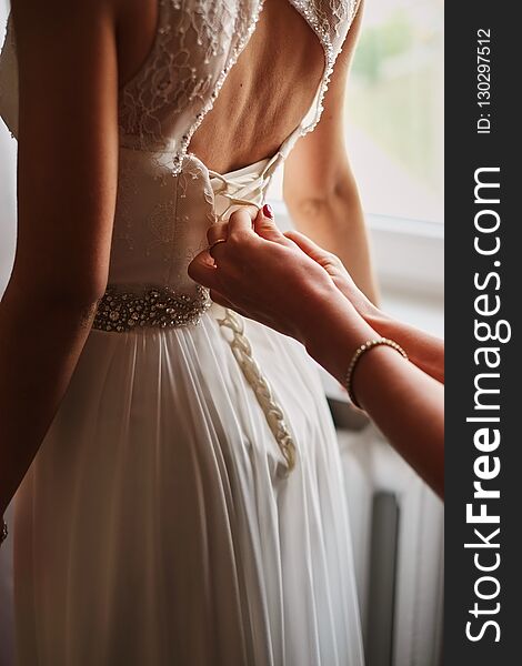 Wedding dress close-up hands knotted corset bride