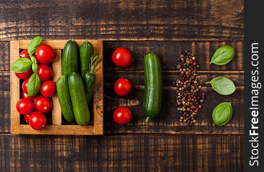 Organic Tomatoes And Cucumbers With Basil And Linen Towel In Vintage Wooden Box On Wooden Kitchen Table. Cooking Concept