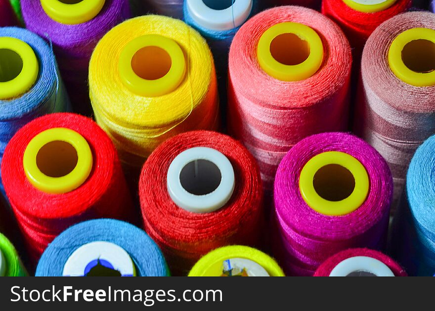 Colored thread for sewing. Threads in spools tape measure, needle bar, needle and scissors on a white background. Colored thread for sewing. Threads in spools tape measure, needle bar, needle and scissors on a white background.