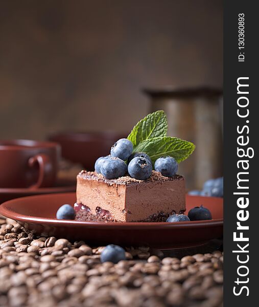 Chocolate cake with blueberries and mint on a brown plate. Chocolate cake with blueberries and mint on a brown plate.