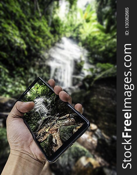 Hand holding big smartphone landscape nature background