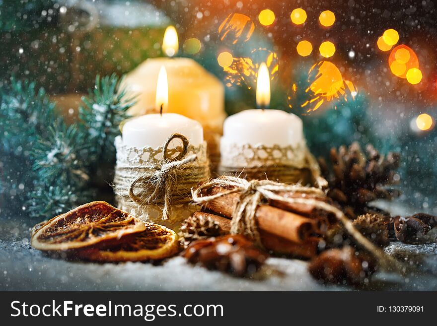 Merry Christmas and happy New year. Candle and Christmas toys on a wooden table. Bokeh. Selective focus.