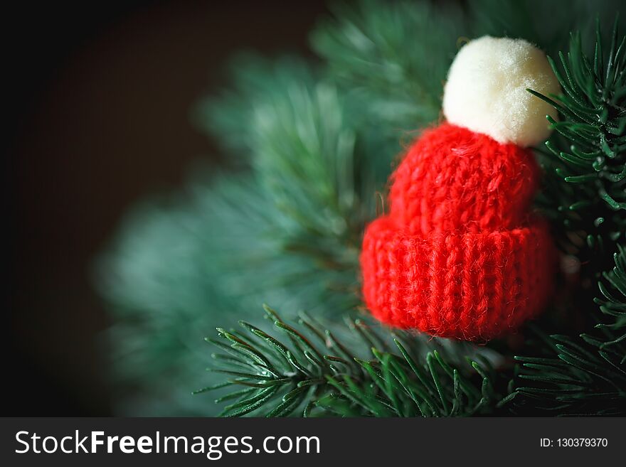 Merry Christmas and happy New year. Little knitted hat on the Christmas tree. Background with copy space.
