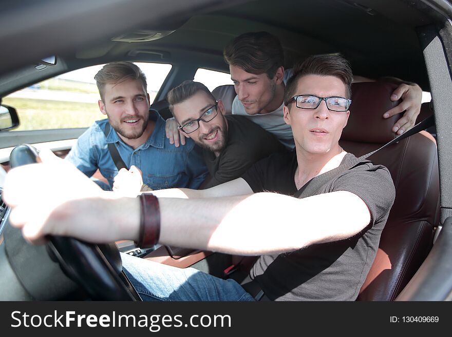 Side View . Friends Sitting In The Car And Looking At The Camera.