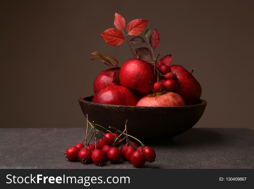 Autumn still life with hawthorn berries and apples in plate.