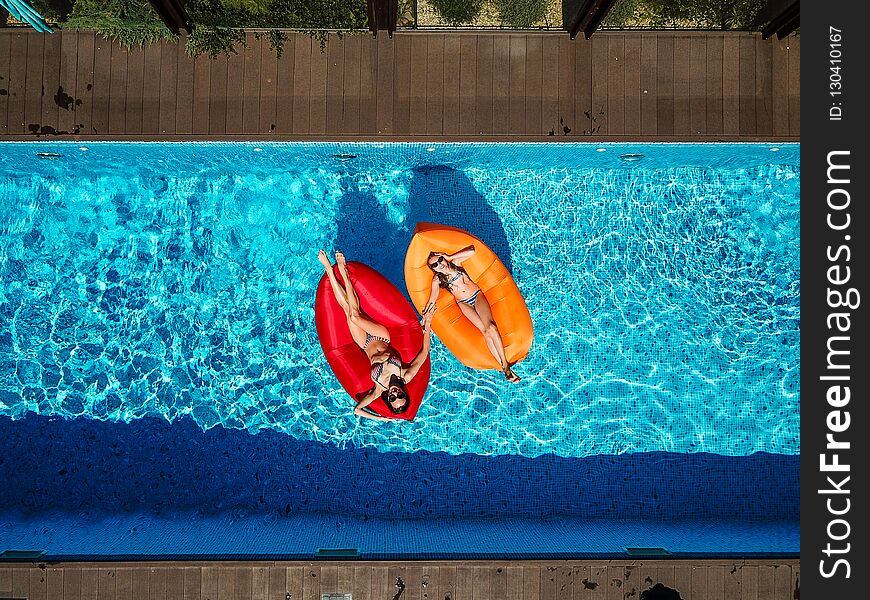 Two Girls Are Swimming In The Pool