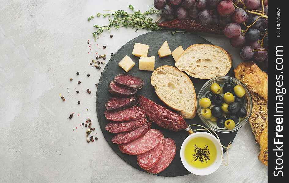 Salami sliced in rustic style. Salami sausage. Different sausages with cheese, grapes and olive. Toned, top view.