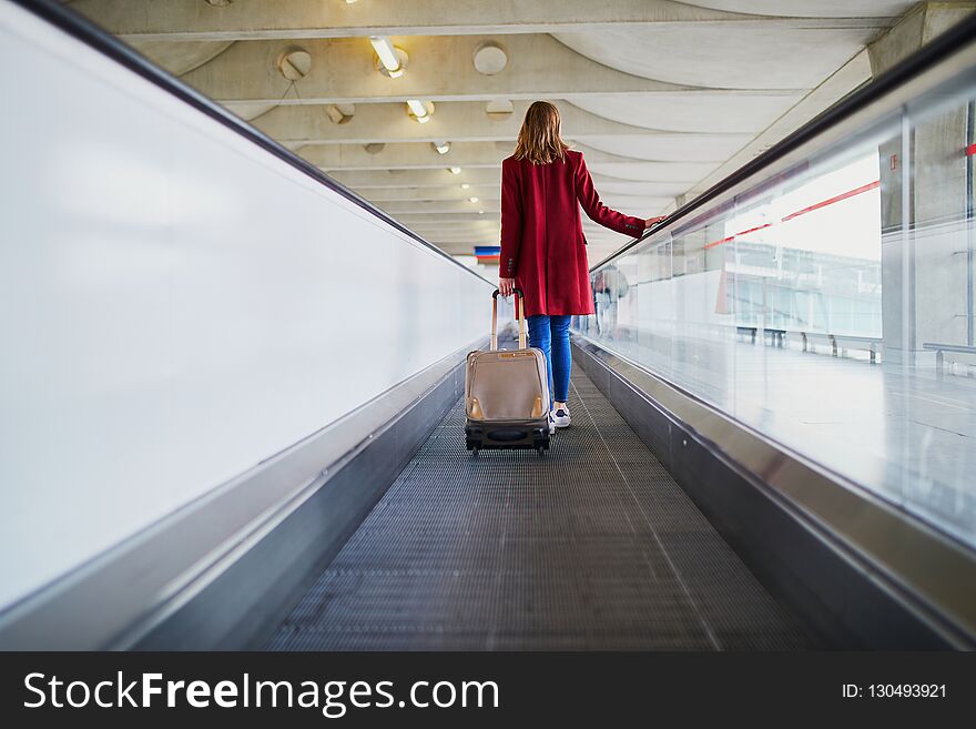 Young woman in international airport with luggage