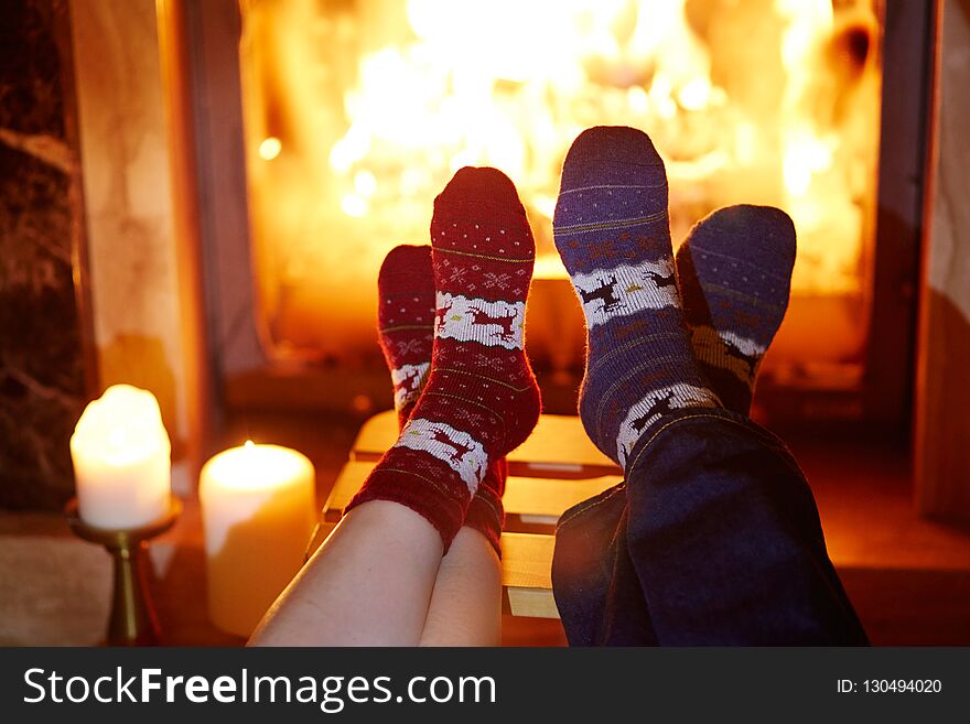 Man and woman in warm socks near fireplace