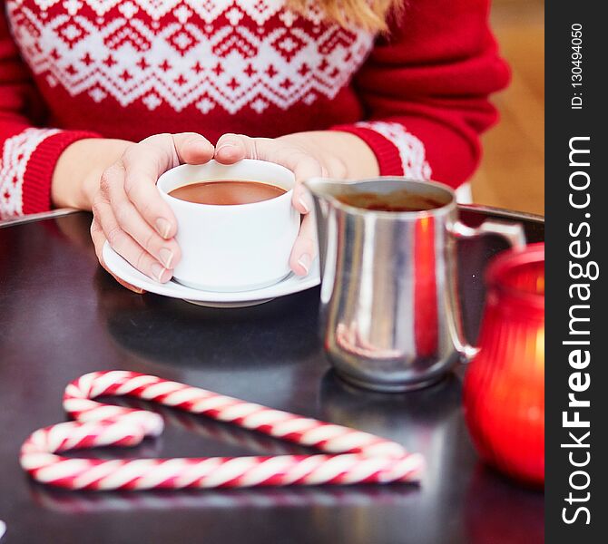 Woman drinking hot chocolate in a cozy outdoor Parisian cafe decorated for Christmas. Woman drinking hot chocolate in a cozy outdoor Parisian cafe decorated for Christmas