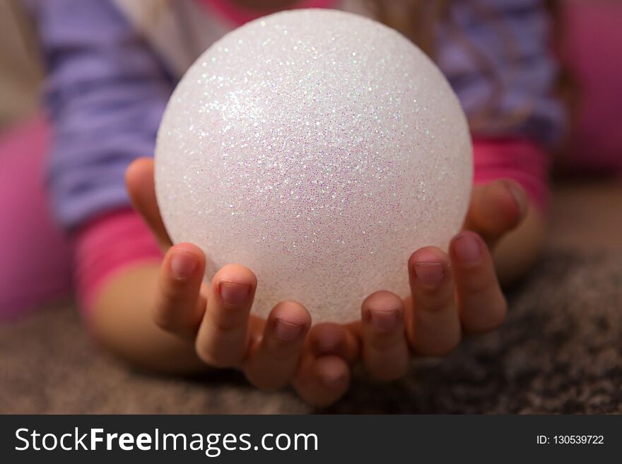 Closeup Of Child’s Hands Holding White Glitter Ball. Closeup Of Child’s Hands Holding White Glitter Ball