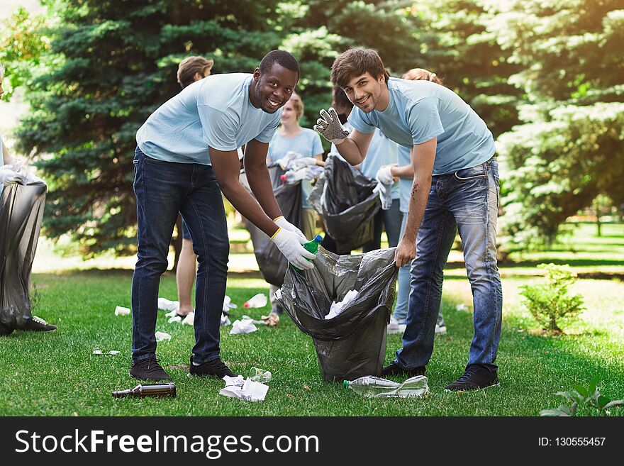 Group Of Volunteers With Garbage Bags Cleaning Park