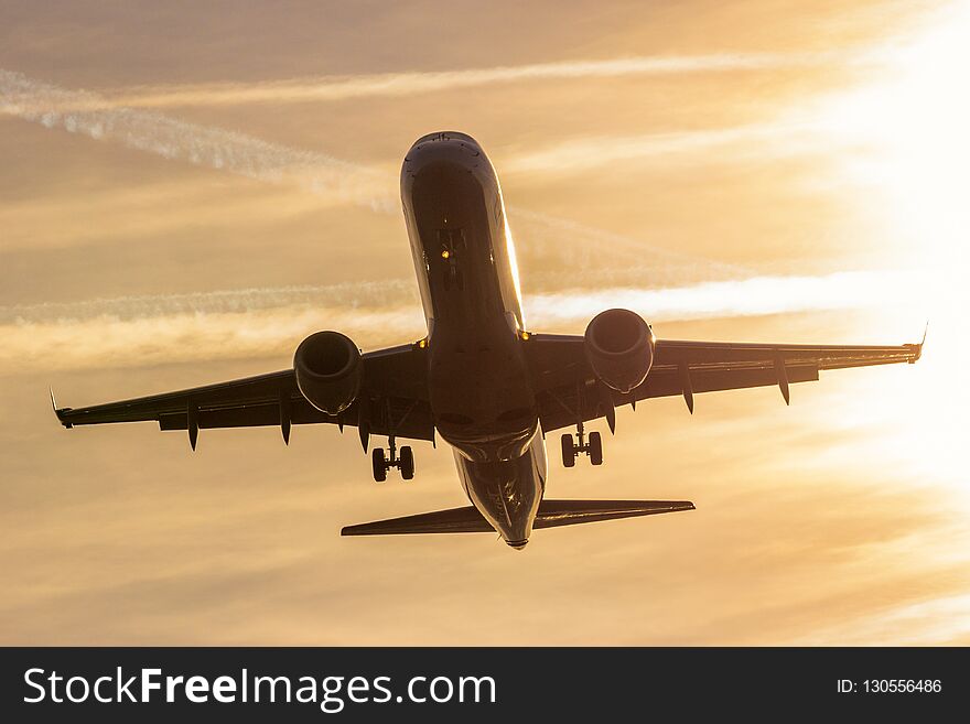 Front view of a passenger airplane landing during sunset. Front view of a passenger airplane landing during sunset