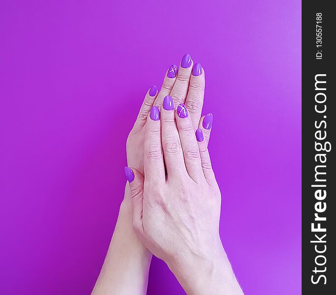 Hands violet manicure on colored paper minimal glamour design fashionable polish trendy beauty. Hands violet manicure on colored paper minimal glamour design fashionable polish trendy beauty