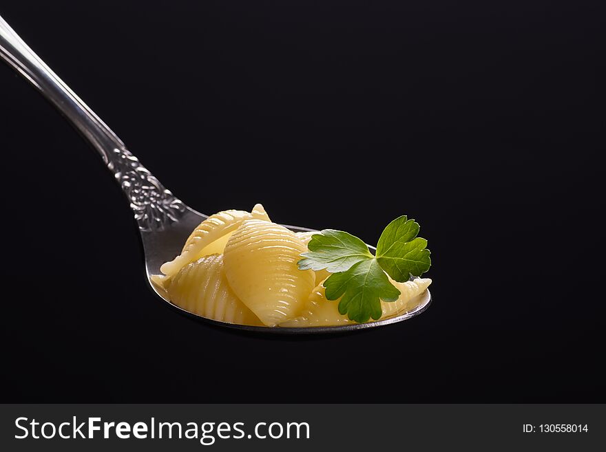 Pasta in a spoon with a leaf of parsley. large