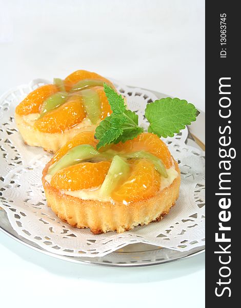 Mandarin tartlet with lemon balm on a silver platter