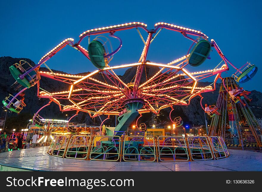 Colorful carousel spinning in the amusement park at night. Colorful carousel spinning in the amusement park at night.