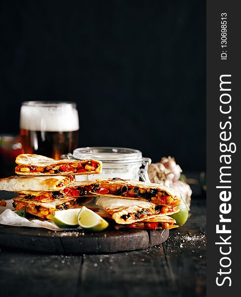 Vegetarian beer snacks: quesadilla with vegetables and cheese on dark background. Vegetarian beer snacks: quesadilla with vegetables and cheese on dark background