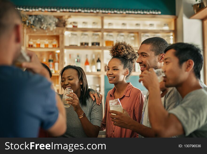 Diverse young friends hanging out together in a bar