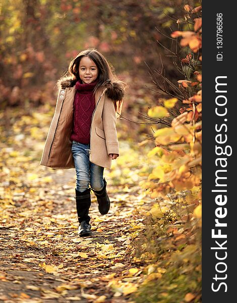 Happy adorable little girl runs in the aun park. happy childhood. Happy adorable little girl runs in the aun park. happy childhood