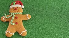 Gingerbread Man With Red Santa Hat Green And White Scarf On A Green Background With Writing Space Stock Photography