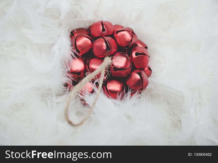 Christmas card. Red Christmas ball on a background of white feathers.