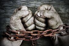 Powerful Dirty Male Hands Clenched Into Fists Chained With Rusty Chain. Stock Image