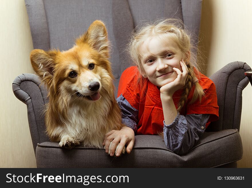 Happy - beautiful blond girl and dog corgi fluffy have fun posing for the camera