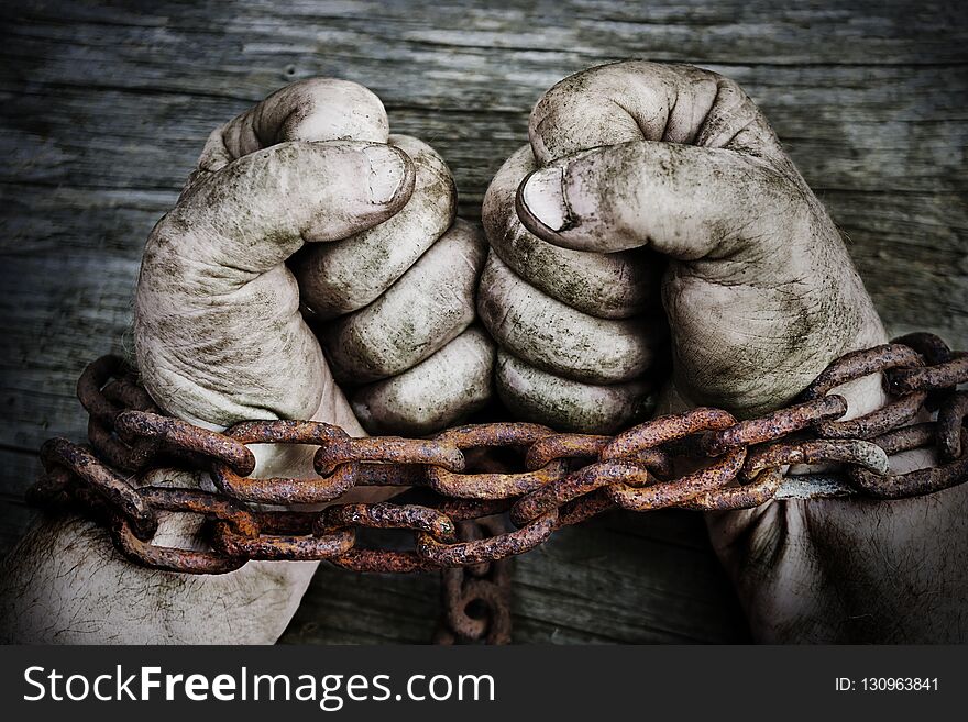 Powerful Dirty Male Hands Clenched Into Fists Chained With Rusty Chain.