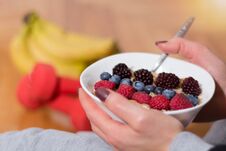 Woman Eating Oats Porridge In Bowl Decorated With Blackberries, Raspberries And Blueberries Royalty Free Stock Photo