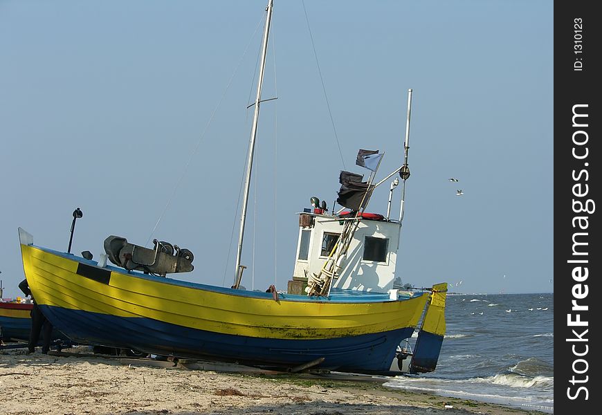 Yellow fishing boat on the shore