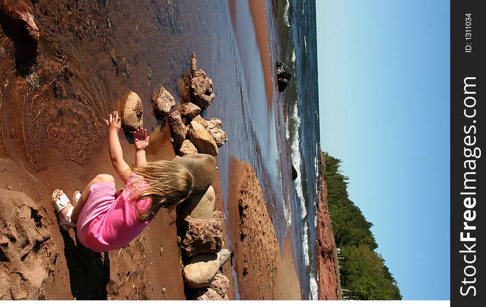 A little girl splashes on the shoreline. A little girl splashes on the shoreline