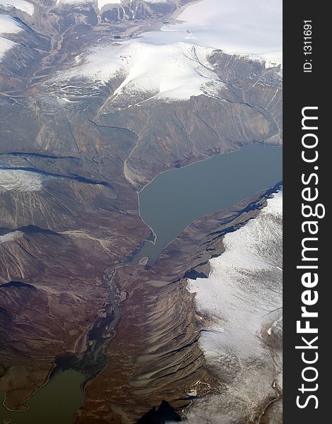 Icy lake in Iceland mountains, aerial view