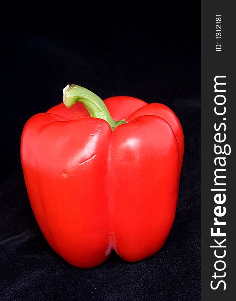 Red bell pepper on a black velvet background.