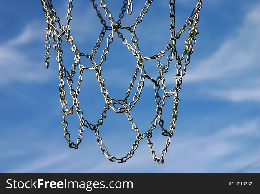 Looking upward thru a basketball hoop and the net is made of chain (instead of rope). Looking upward thru a basketball hoop and the net is made of chain (instead of rope)