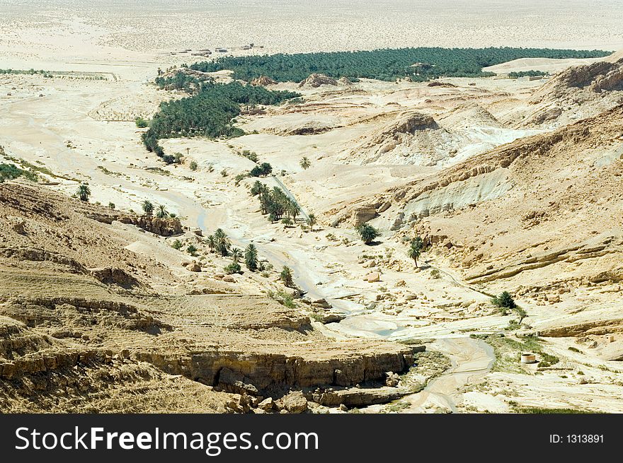 Stunning wide landscape of canyon with the river and oasis below, Tunisia. Stunning wide landscape of canyon with the river and oasis below, Tunisia