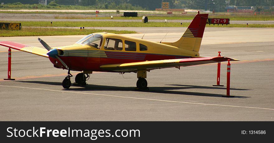 Red and Yellow airplane on tarmac. Red and Yellow airplane on tarmac