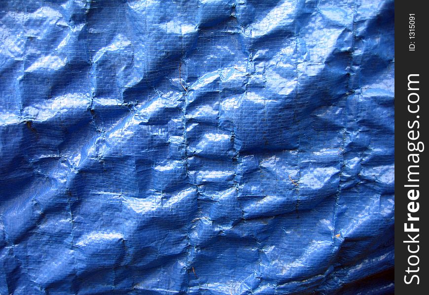 Wrinkled blue tarpaulin makes a complex background