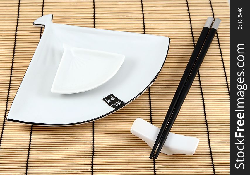 Sushi plate and chopsticks on bamboo mat. Sushi plate and chopsticks on bamboo mat