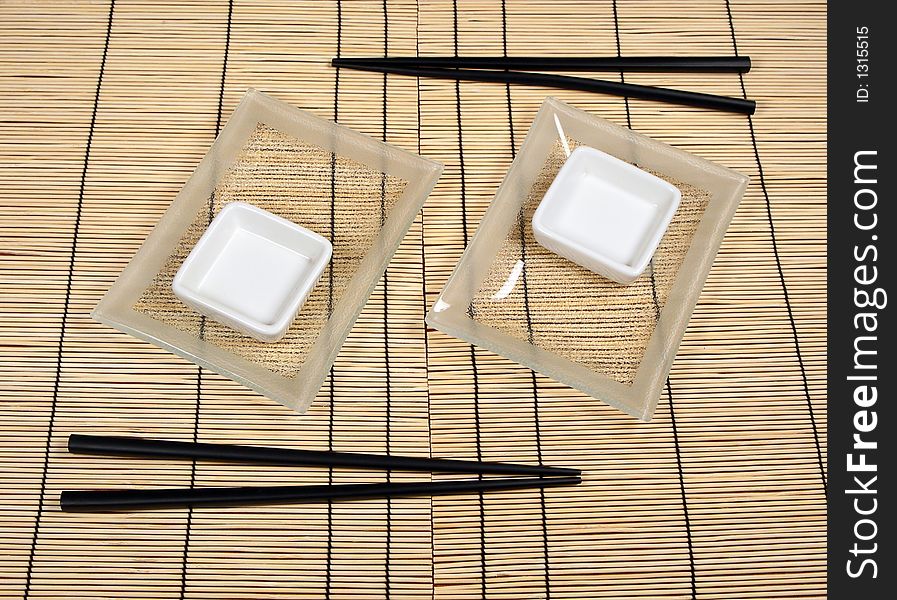 Sushi plates and chopsticks on bamboo mat. Sushi plates and chopsticks on bamboo mat