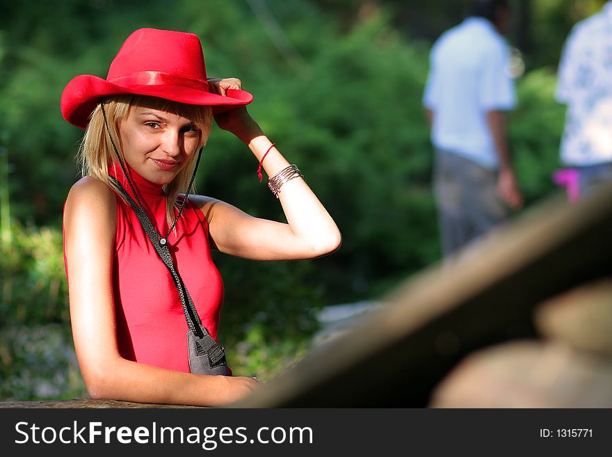 Beautiful sexy blonde cowgirl in the countryside with red hat