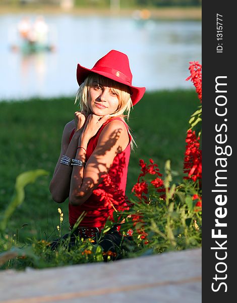 Beautiful blonde cowgirl in the countryside with red hat. Beautiful blonde cowgirl in the countryside with red hat