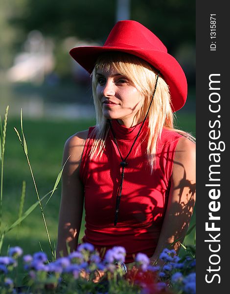 Beautiful blonde cowgirl in the countryside with red hat. Beautiful blonde cowgirl in the countryside with red hat