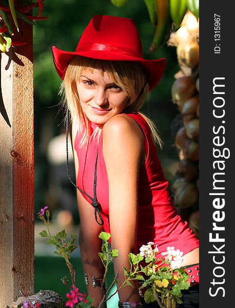 Beautiful blonde cowgirl in the countryside with red hat. Beautiful blonde cowgirl in the countryside with red hat