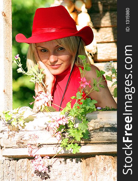Beautiful sexy blonde cowgirl in the countryside with red hat